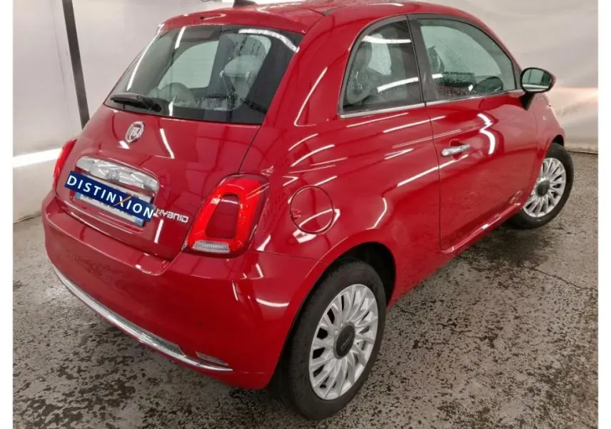 Vue 3/4 arrière droite d'une FIAT 500 Dolcevita rouge avec logo Hybrid et jantes multibranches en intérieur.