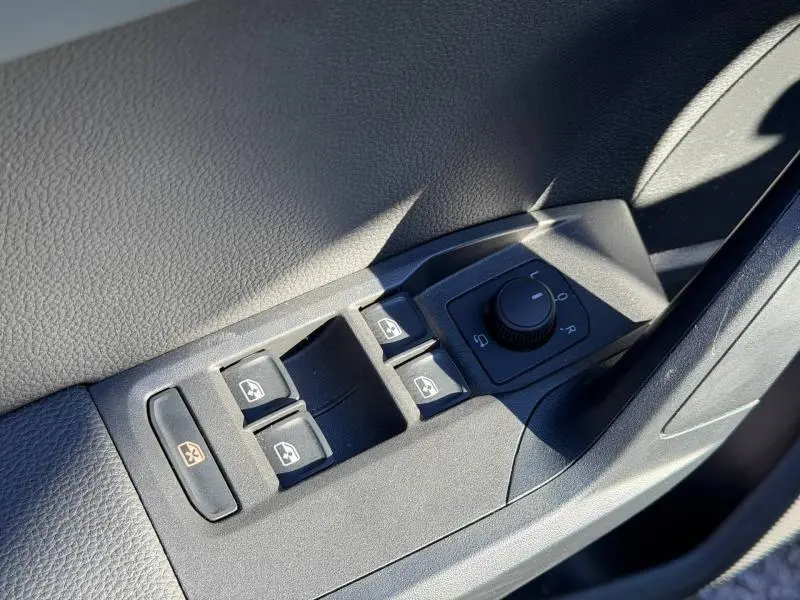 Détail des commandes de lève-vitres et réglage des rétroviseurs côté conducteur dans l’habitacle noir du SEAT Arona 2025.