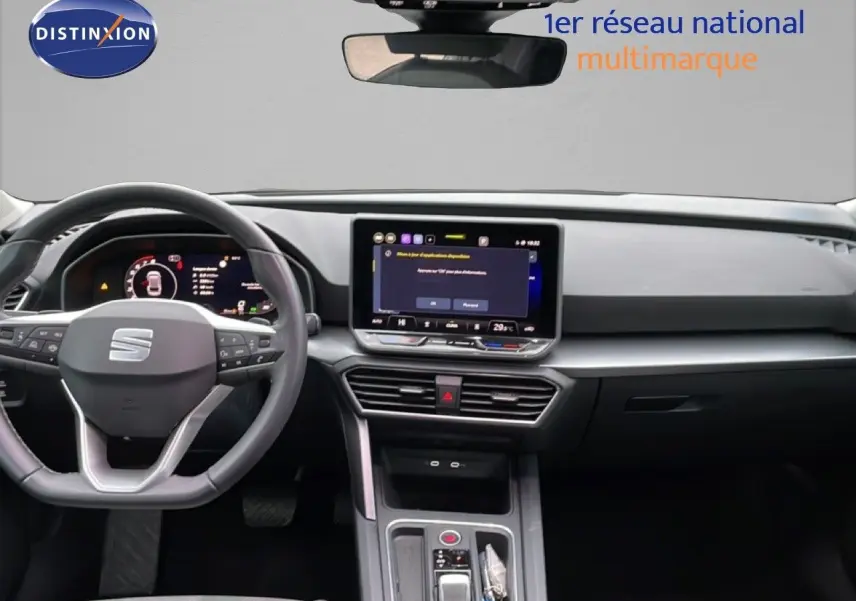 Intérieur de la SEAT Leon 2025 en vue frontale, tableau de bord moderne avec écran tactile central et volant multifonction.