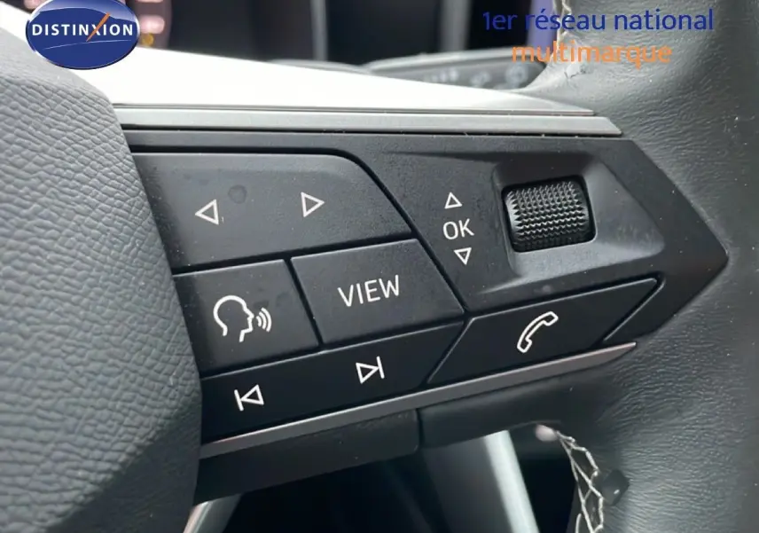 Gros plan sur les commandes multifonctions au volant d'une SEAT LEON IV 1.5 TSI 115 DSG Style gris Fiord, 2025.