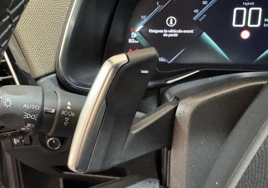 Gros plan sur la palette de changement de vitesse en aluminium du DS7 Crossback E-TENSE 225, tableau de bord numérique visible.