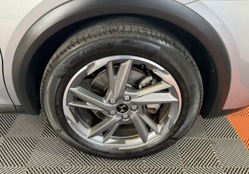 Gros plan sur la roue avant droite du DS7 Crossback gris foncé, mettant en valeur la jante alliage au design moderne.