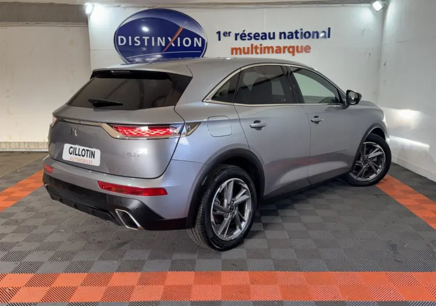DS7 Crossback E-TENSE gris foncé vu en 3/4 arrière droit, avec feux arrière allumés et jantes alliage.