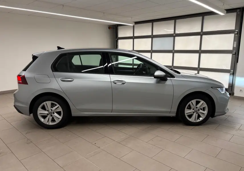 Vue latérale droite d'une Volkswagen Golf 2.0 TDI 116 BVM6 Life Plus 2025 en reflet d'argent dans un garage.