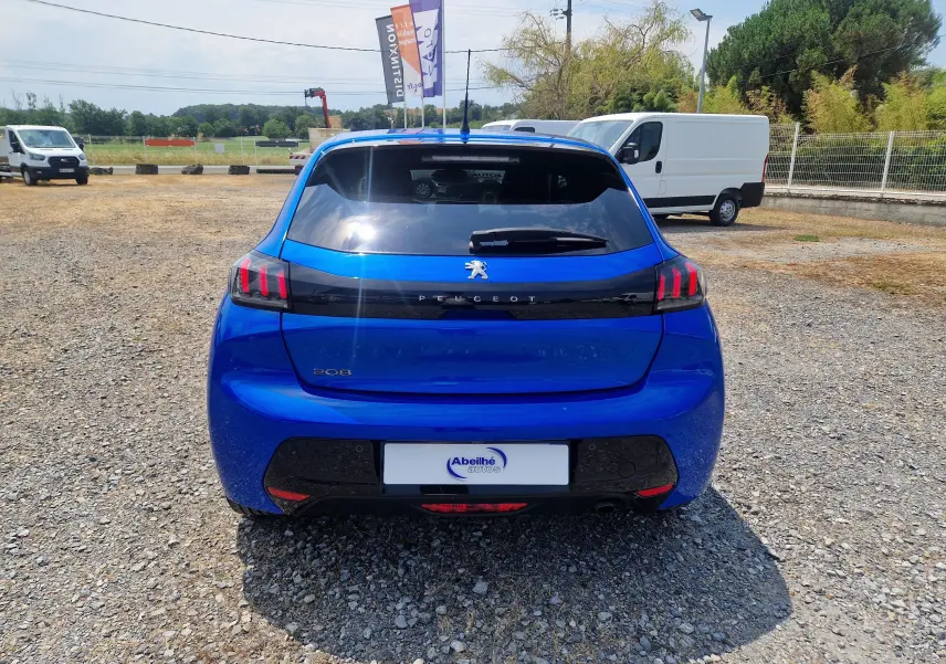 Vue arrière d'une Peugeot 208 1.2 PureTech 110 Allure Pack bleu Vertigo, avec feux arrière à griffes rouges distinctifs.
