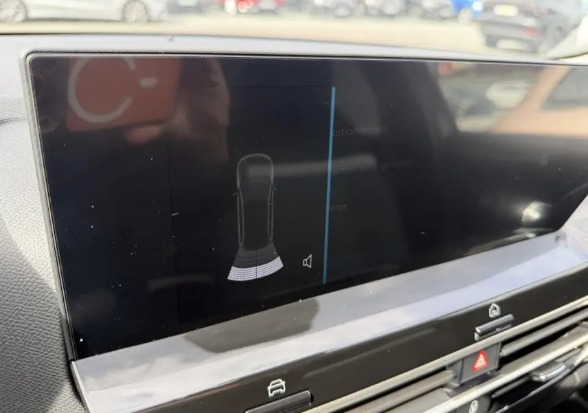 Écran tactile central affichant l'alerte radar arrière dans l'habitacle d'une Citroën C4 ë-136 noir.