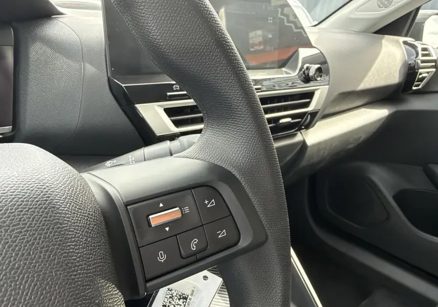 Vue rapprochée du volant et tableau de bord noir de la Citroën C4 ë-136 2025 avec commandes intégrées au volant.