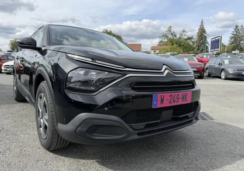 Citroën C4 ë-136 2025 noir, vue 3/4 avant droit, avec inserts noir brillant autour des antibrouillards.