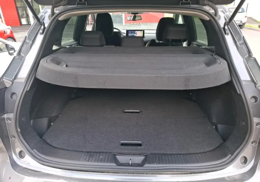 Coffre ouvert vu de l'arrière d'un Nissan Qashqai e-POWER gris foncé 2023 avec cache-bagages en place.