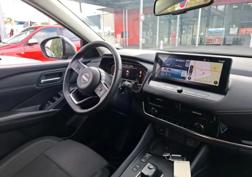 Vue intérieure côté conducteur du Nissan Qashqai e-POWER 2023 avec tableau de bord numérique et écran tactile central.
