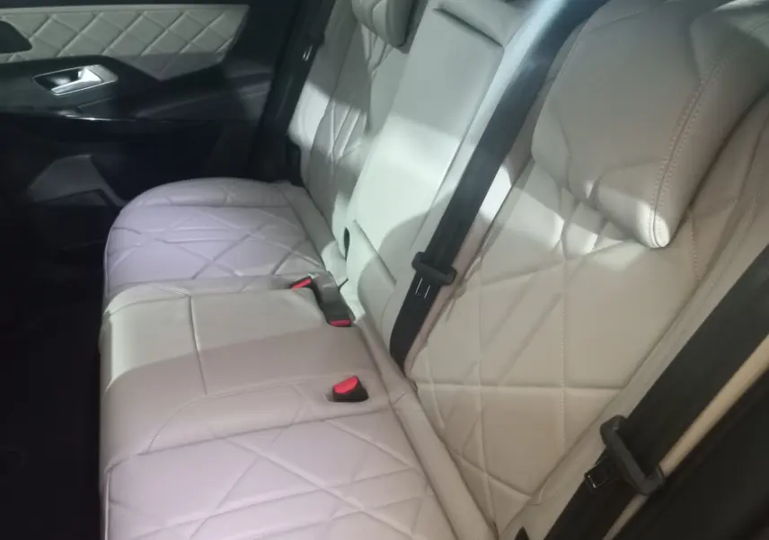 Vue latérale des sièges arrière en cuir beige matelassé du DS7 Crossback, avec ceinture de sécurité noire visible.