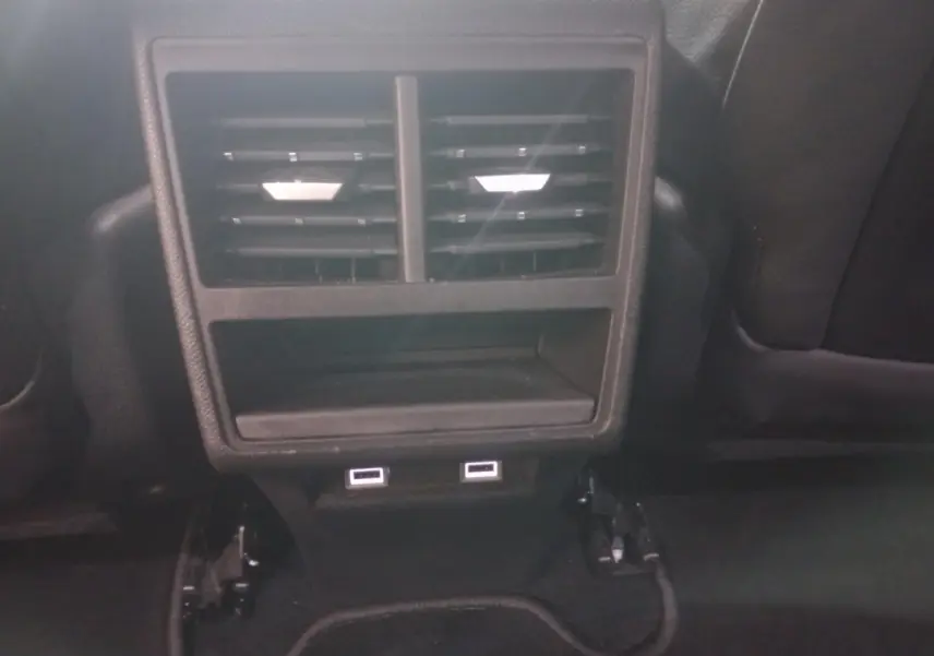 Vue rapprochée des aérateurs arrière et des deux ports USB noirs dans l’habitacle du DS7 Crossback gris foncé.