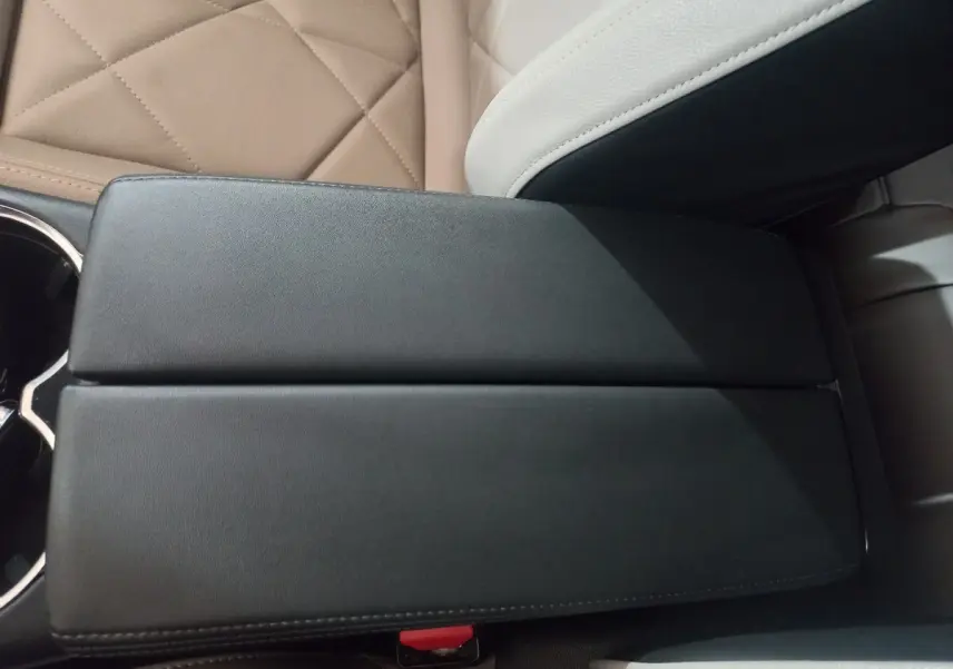 Vue rapprochée de l'accoudoir central noir et des sièges en cuir beige clair du DS7 Crossback 2021.