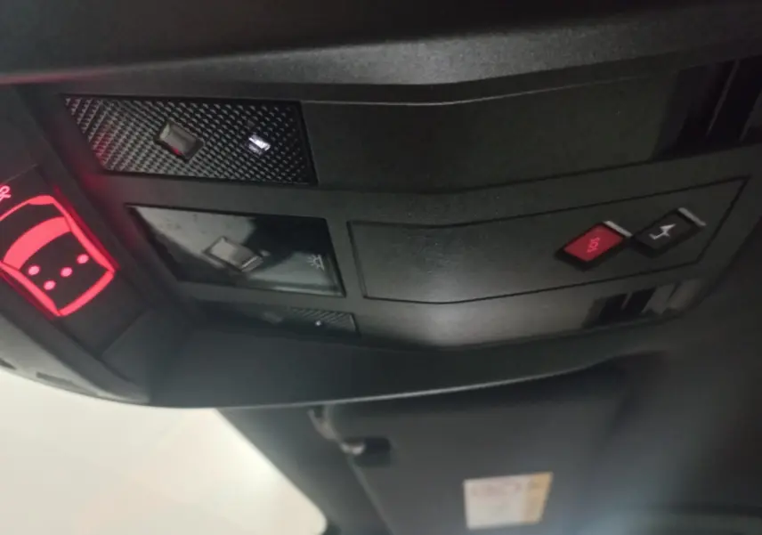 Vue intérieure du plafond avant du DS7 Crossback gris foncé, avec boutons SOS et éclairage intégrés.