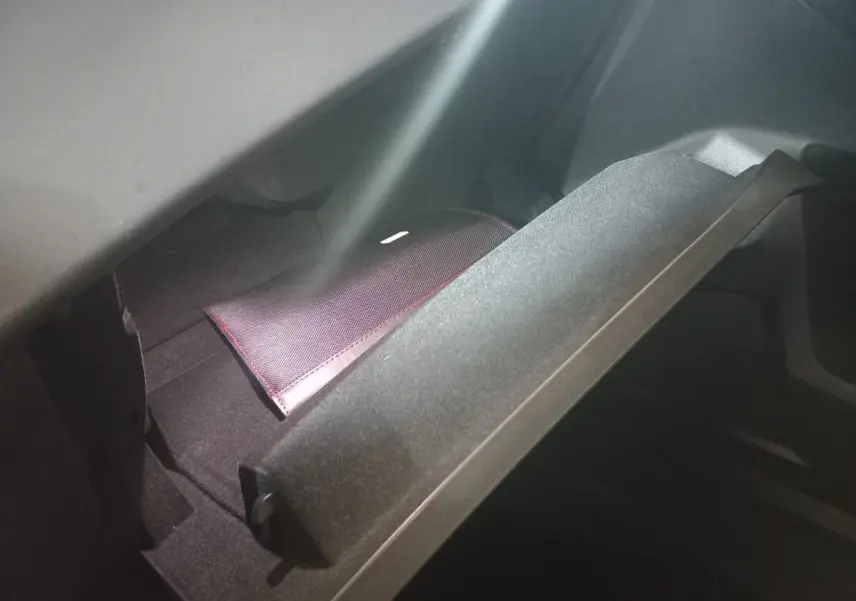 Gant de boîte à gants ouvert montrant un étui noir avec surpiqûres rouges dans un DS7 Crossback gris foncé.