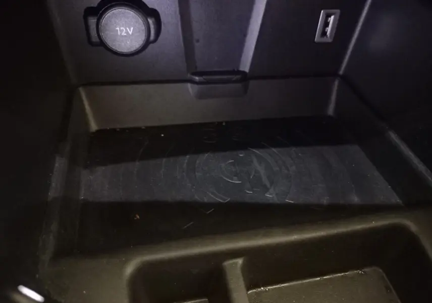 Gros plan sur la zone de recharge par induction et prise 12V du DS7 Crossback gris foncé, intérieur console centrale.