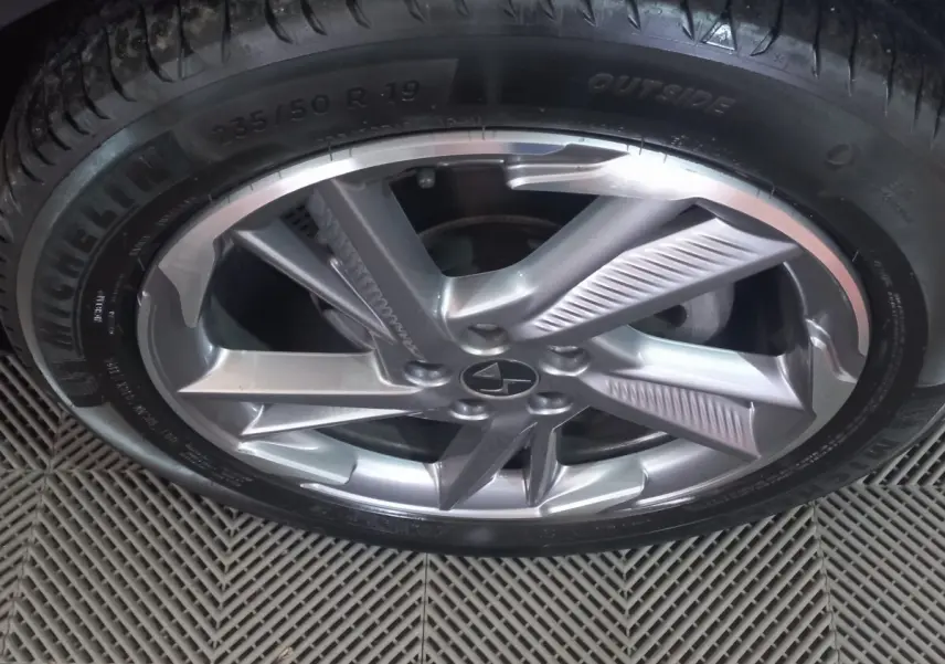 Gros plan sur la jante alliage argentée et pneu Michelin du DS7 Crossback gris foncé, vue de dessus.