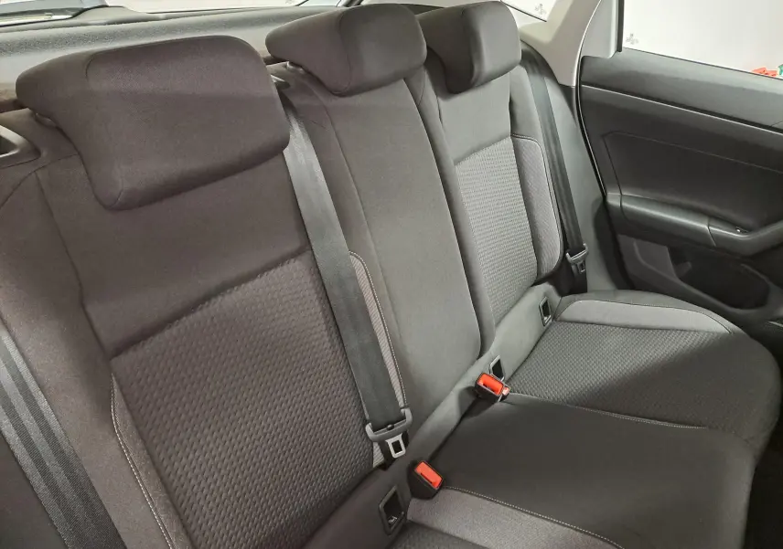 Vue intérieure du siège arrière droit de la Volkswagen Polo 2024 blanc pur, avec ceintures de sécurité et appuie-têtes noirs.