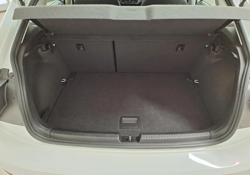 Coffre ouvert vu de l'arrière d'une Volkswagen Polo blanc pur 2024, montrant un espace de chargement propre et spacieux.