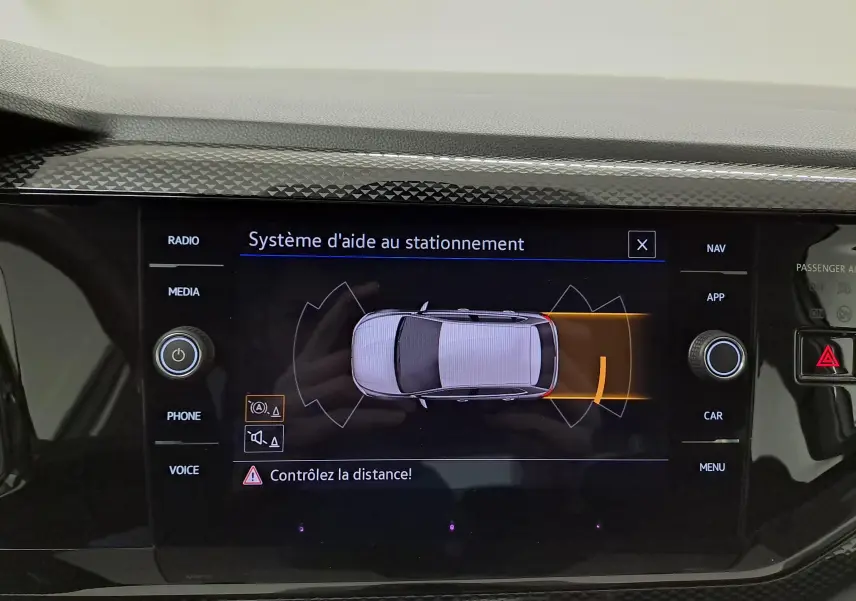 Écran tactile du système d'aide au stationnement de la Volkswagen Polo 2024 en blanc pur, vue intérieure centrale.