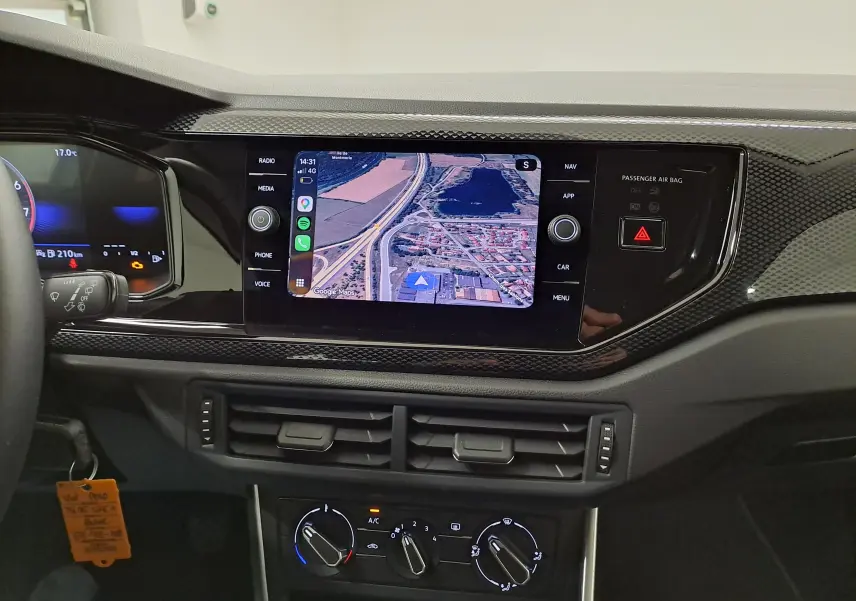 Vue intérieure du tableau de bord de la Volkswagen Polo blanc pur 2024 avec écran tactile affichant la navigation.