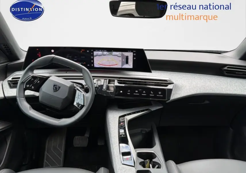 Vue intérieure du tableau de bord et volant cuir gris du Peugeot 3008 2025 avec écran tactile et caméra de recul affichée.