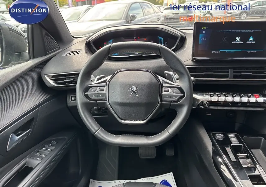 Vue intérieure centrée sur le volant cuir noir du Peugeot 3008 Hybrid 2024 avec tableau de bord digital et écran tactile.