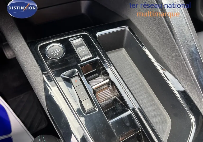Gros plan sur la console centrale noire brillante du Peugeot 3008 Hybrid 180ch, avec bouton start/stop et sélecteur de mode de conduite.