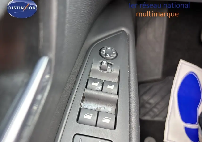 Gros plan sur les commandes des vitres électriques côté conducteur du Peugeot 3008 noir métal hybride 2024.