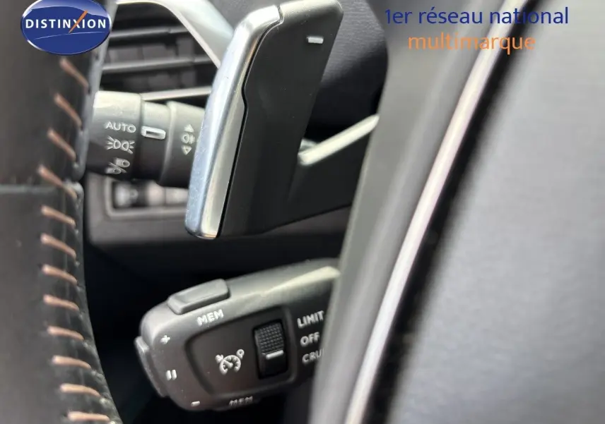 Détail du levier de commande du régulateur de vitesse sur le volant d’un Peugeot 3008 Hybrid 180ch noir métal.