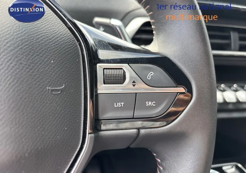 Gros plan sur les commandes gauche du volant cuir noir du Peugeot 3008 Hybrid 2024, avec boutons LIST et SRC visibles.