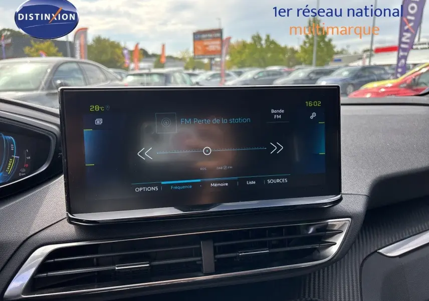 Écran tactile central du tableau de bord du Peugeot 3008 noir métal 2024, affichant la radio FM en extérieur.