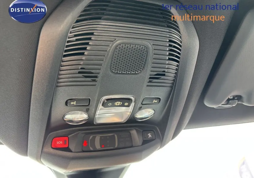 Vue en contre-plongée du plafonnier noir avec commandes d’éclairage et bouton SOS du Peugeot 3008 Hybrid 2024.
