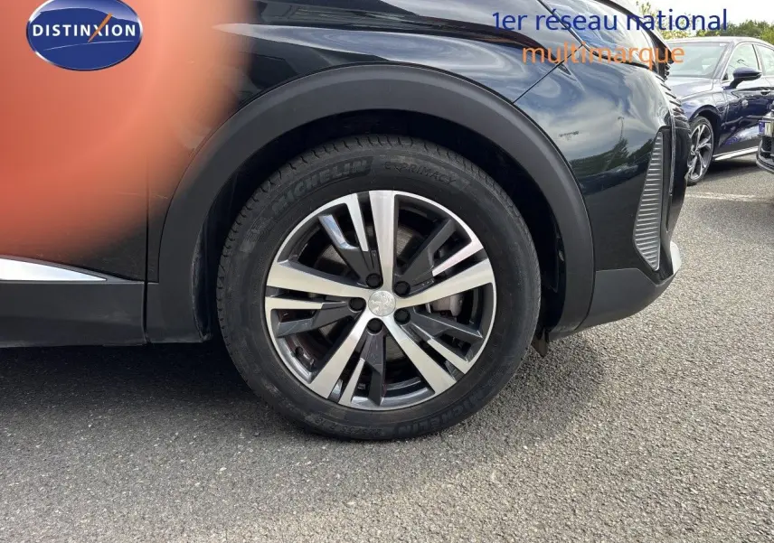 Gros plan sur la roue avant gauche du Peugeot 3008 noir métal, mettant en valeur la jante alliage et le pneu Michelin.
