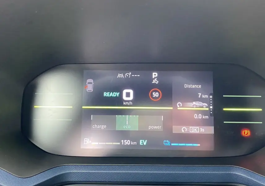 Tableau de bord numérique du Dacia Duster hybride 2025 affichant vitesse, mode éco et autonomie électrique.