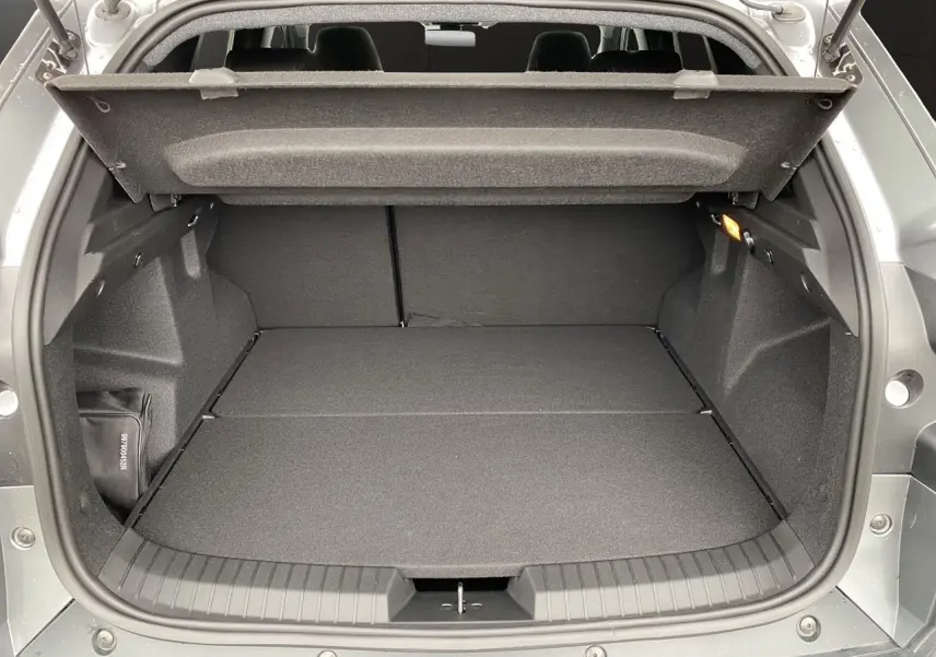 Coffre ouvert du Dacia Duster gris schiste, vue arrière montrant un espace de chargement plat et spacieux.