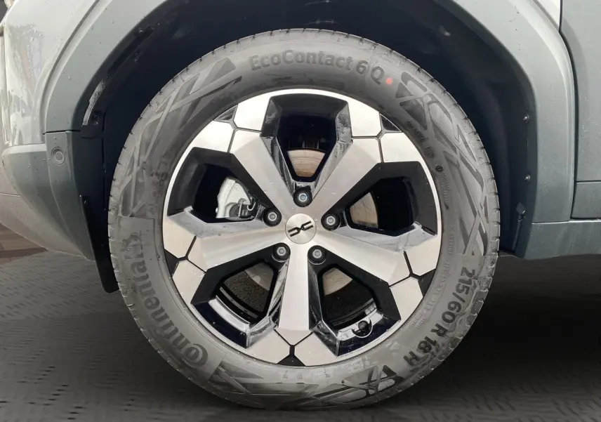 Gros plan sur la roue avant droite du Dacia Duster gris schiste, mettant en valeur la jante alliage au design moderne.