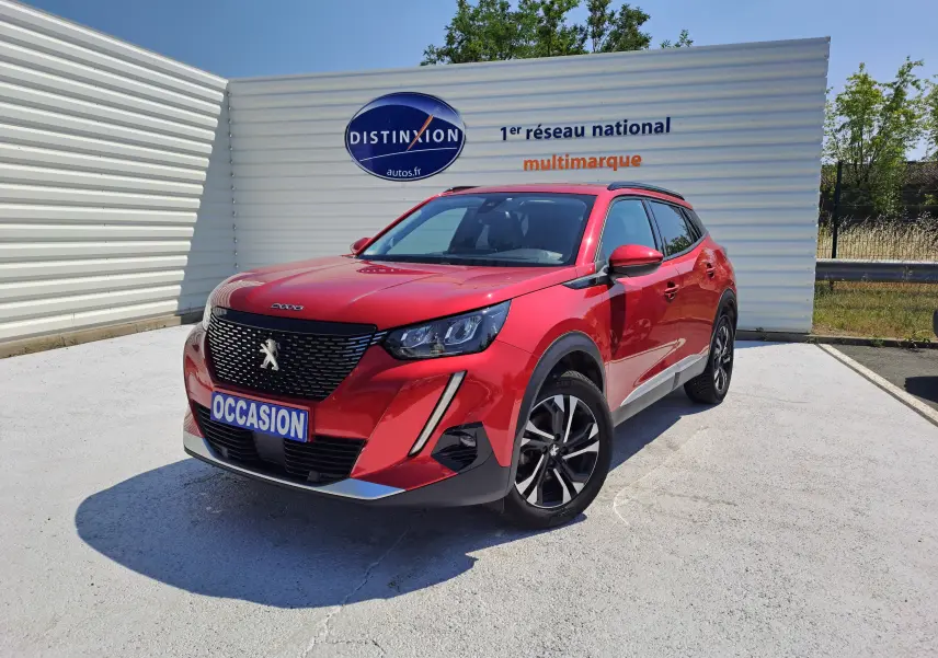 Peugeot 2008 rouge vue en 3/4 avant droit avec calandre noire et jantes alliage bicolores.