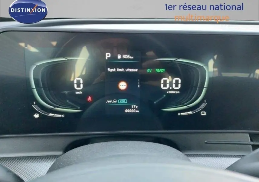 Tableau de bord numérique du Kia Sportage hybride 2024 affichant vitesse, régime et autonomie, vu de face depuis le poste de conduite.