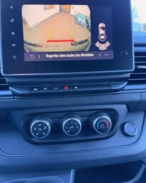 Vue intérieure du tableau de bord du Renault Trafic Fourgon gris clair 2025, écran tactile affichant la caméra de recul.