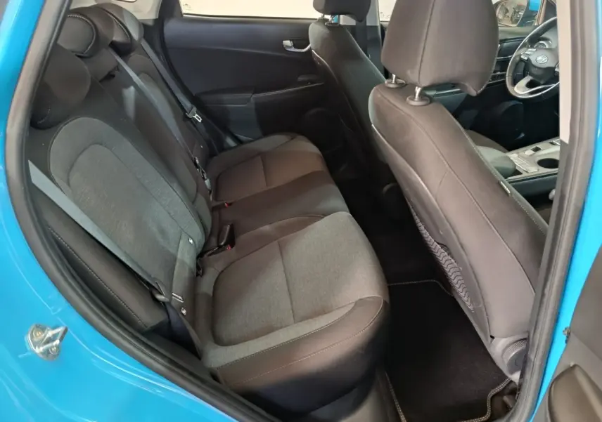 Vue intérieure côté gauche montrant la banquette arrière grise et noire du Hyundai Kona électrique bleu 2022.
