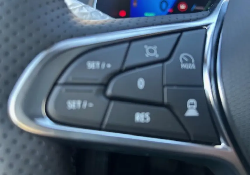 Gros plan sur les commandes noires du volant en textile de la Renault Symbioz 2025, avec contour chromé.