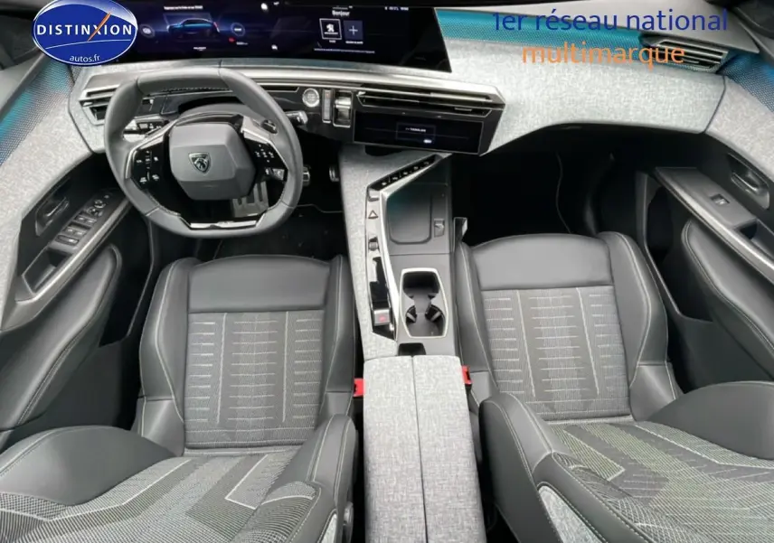 Intérieur du Peugeot 3008 blanc 2025 vu de dessus, avec sièges tissu et cuir gris et console centrale moderne.