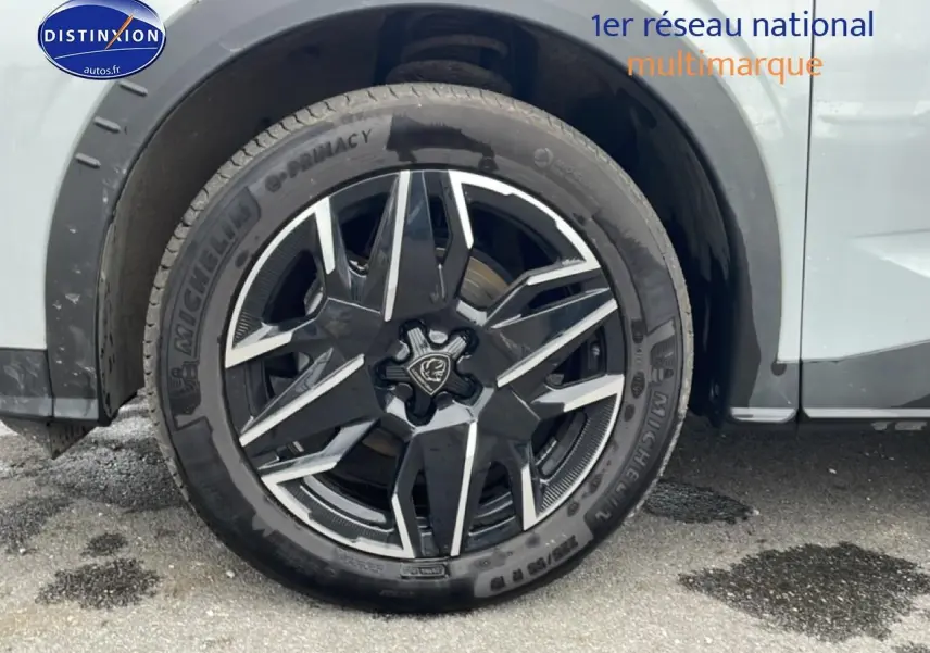 Gros plan sur la jante alu noire et argentée du côté avant droit d’un Peugeot 3008 blanc.