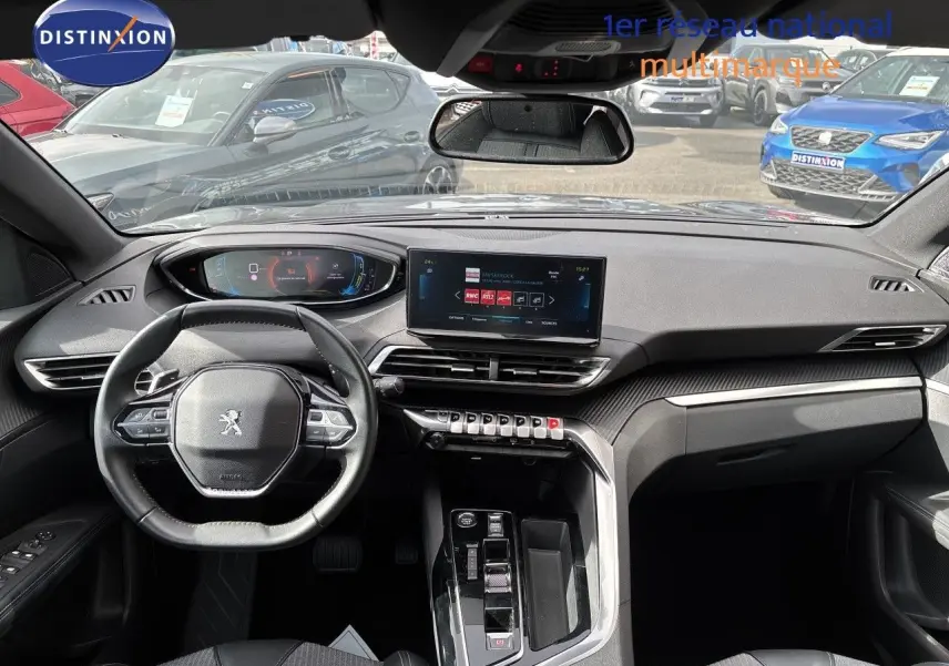 Vue intérieure avant du Peugeot 3008 Hybrid 180ch Allure 2024, tableau de bord moderne avec écran tactile et volant multifonction noir.