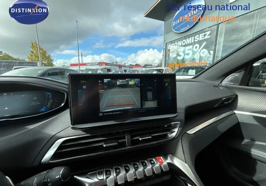 Vue intérieure du tableau de bord du Peugeot 3008 Hybrid 2024, écran central affichant la caméra de recul, ambiance noire et moderne.