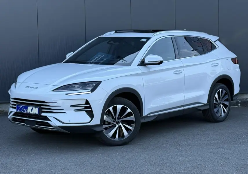 Vue 3/4 avant droite du SUV BYD SEAL U blanc Snow White avec jantes alliage bicolores et barres de toit en aluminium.
