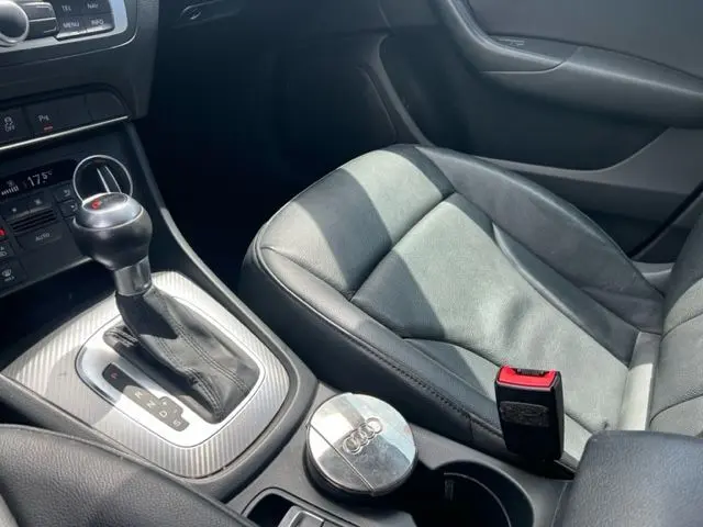 Intérieur de l'Audi Q3 2015 blanc, vue sur le levier de vitesse automatique et siège passager en cuir noir.