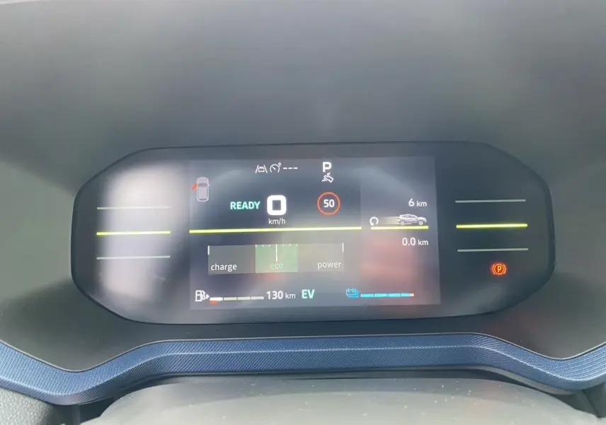 Tableau de bord numérique du Dacia Duster hybride 2025 affichant la vitesse, autonomie et mode éco en vue frontale.