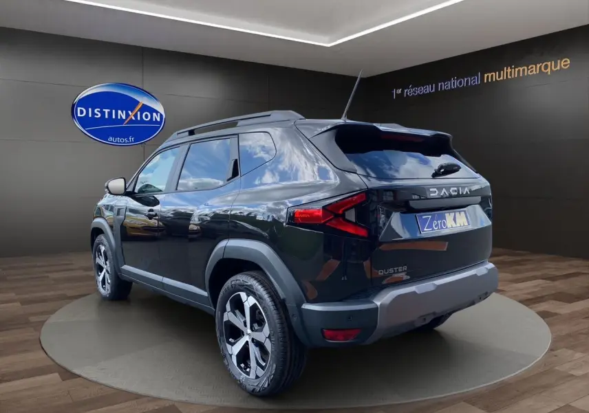Vue 3/4 arrière droite du Dacia Duster hybride noir avec jantes alliage et détails de protection plastique gris.